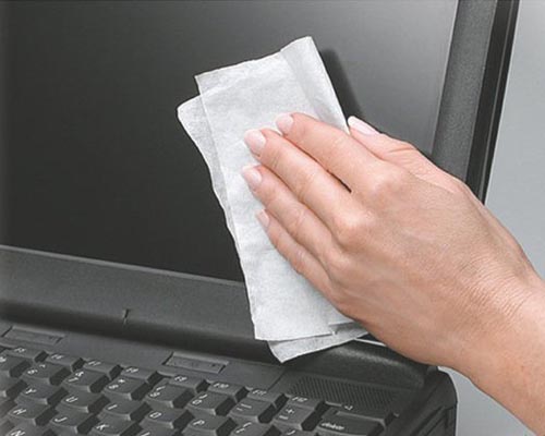图为用湿巾擦拭电脑屏幕